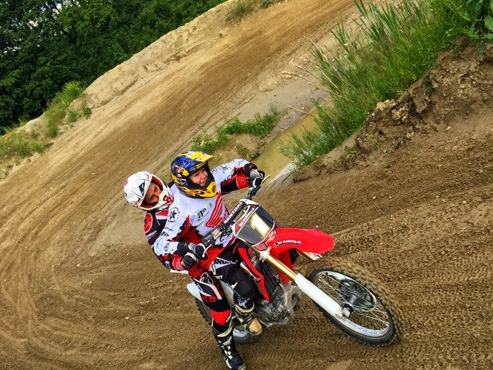 Motocross für Anfänger: Trainer fährt in der Kurve hinter einer Einsteigerin